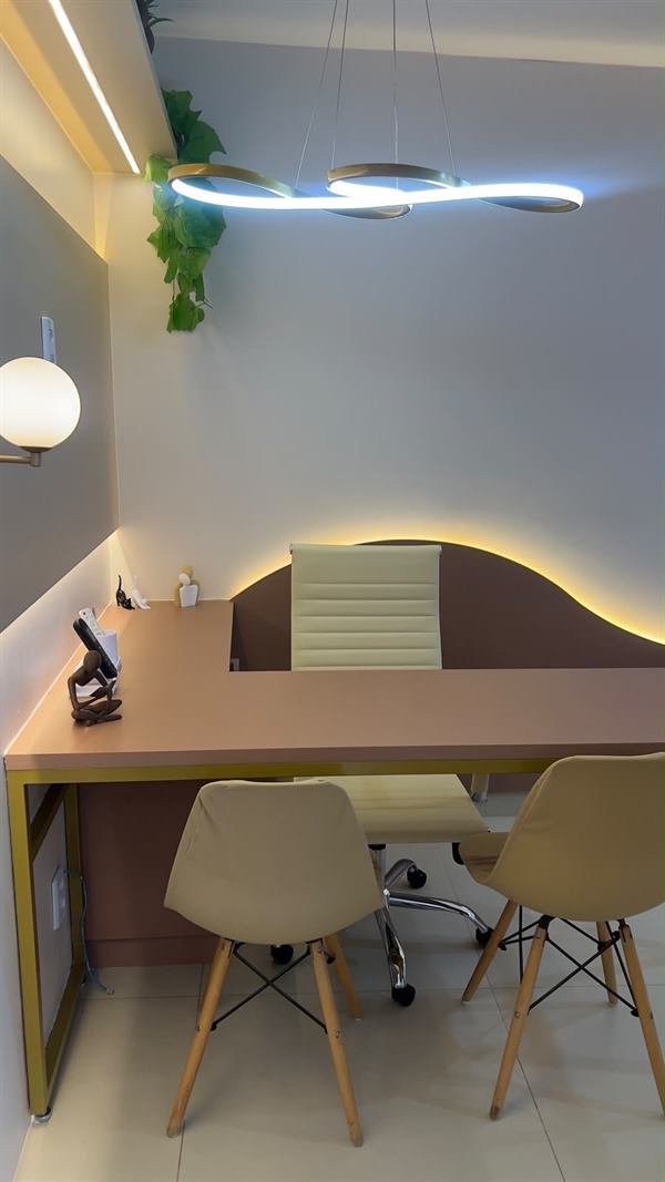 Detalhe da mesa, das cadeiras de apoio e do pendente luminoso
